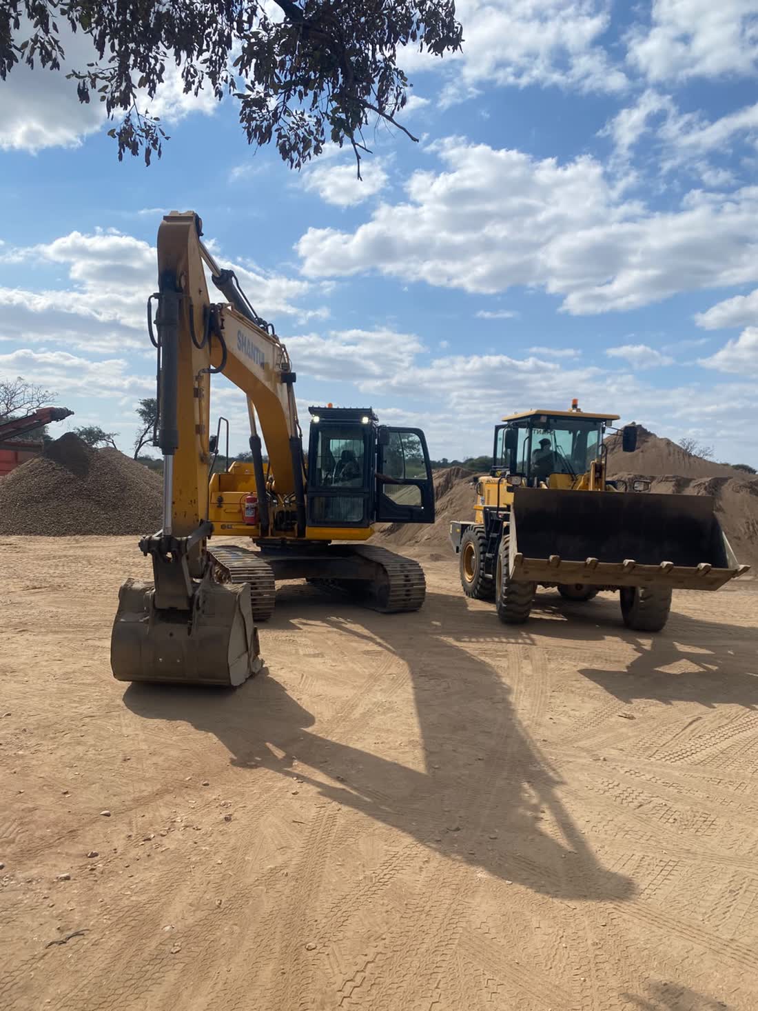 Excavator loading sand into a tipper truck